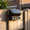 GlowGuard solar wandlamp op houten schutting in Nederlandse tuin